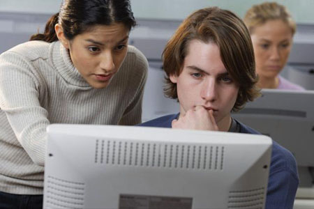 Students talking around a computer