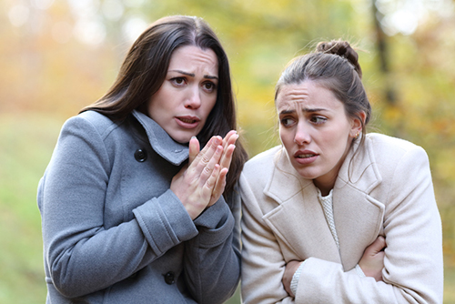 two women in coats shivering