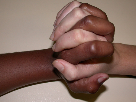 A black hand holding a white hand