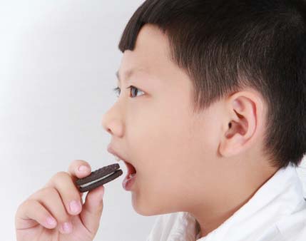 Boy eating Oreo cookie.