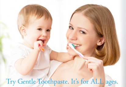 A mom holds her baby. The ad reads Try Gentle Toothpaste. It's for ALL ages.