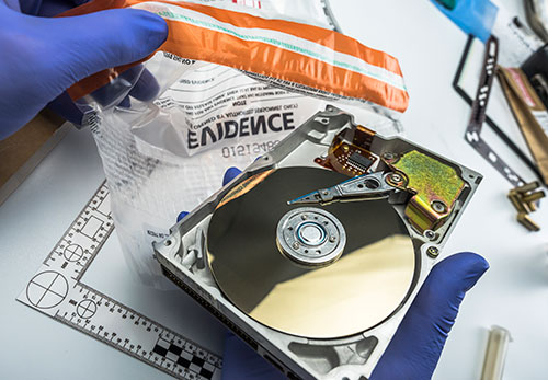 A hard drive with its casing removed, revealing the magnetic disk and actuator arm inside.