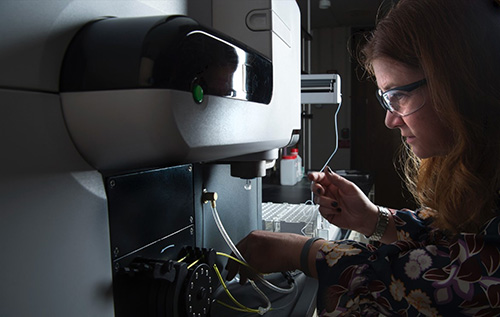 A lab technician using a spectrometer.