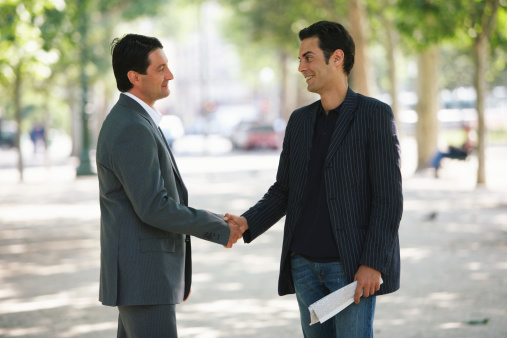 Two French men shaking hands.