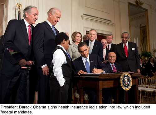 President Barack Obama signs health insurance legislation.