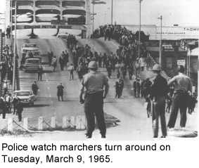 Police watch marchers turn around on Tuesday, March 9, 1965.