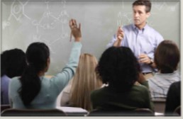 teacher standing in front of class teaching as students ask questions