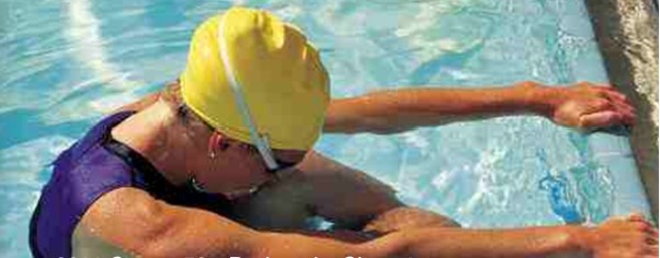swimmer in pool holding onto side of pool