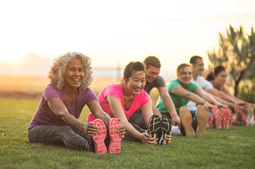 Group of people stretching outside.