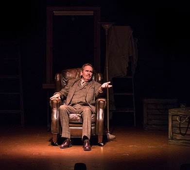 a man sitting in a chair facing the audience