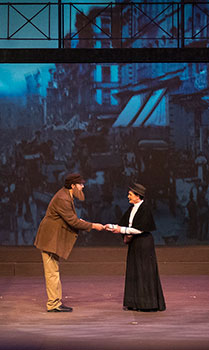 a man and a woman on stage facing each other holding hands