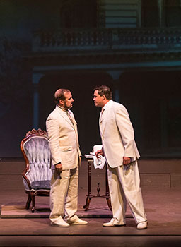 two men on stage slightly facing each other with their downstage feet angled toward the audience