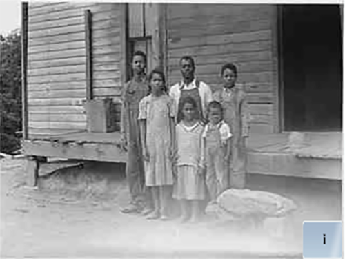 An African-American family stands outside their home