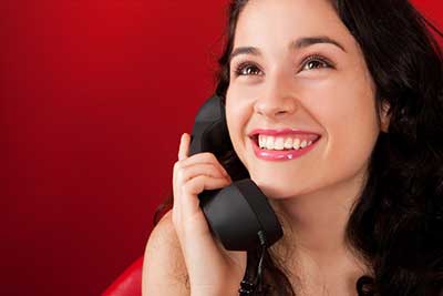 young lady talking on corded telephone